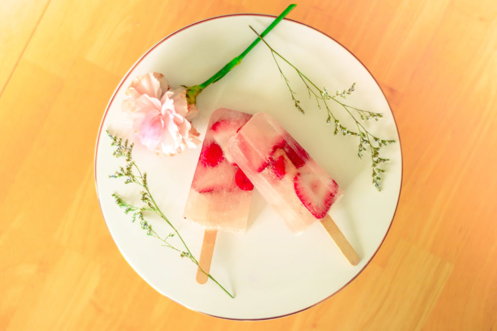 Gorgeous Rosé Popsicles on a white platter with flowers