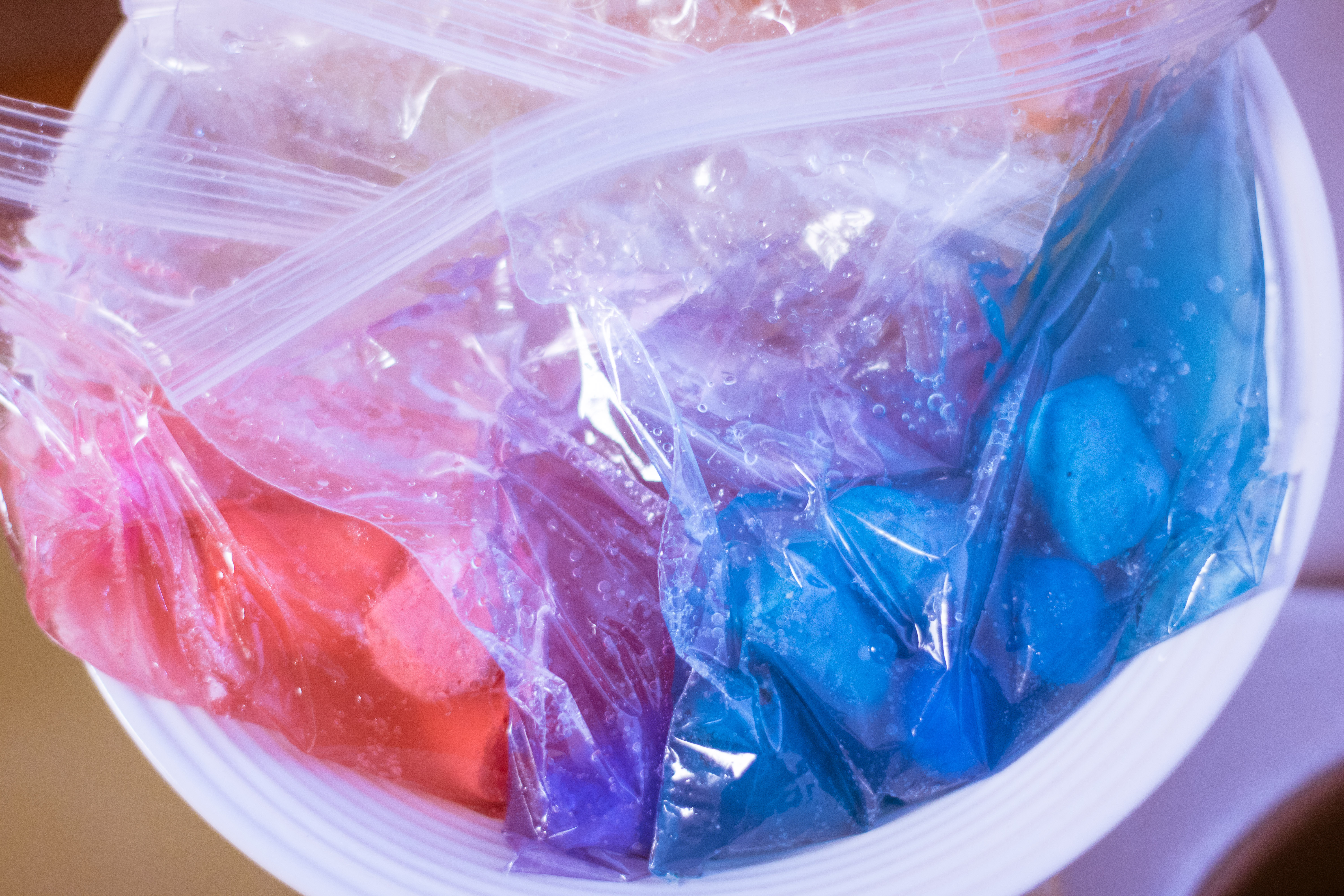 Place all the bags of chalk and water zipper-side-up in a large bowl to make your sidewalk chalk paint